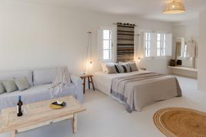 un soggiorno bianco con letto e divano di Scorpios Beach a Monolithos