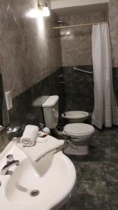 a bathroom with a white sink and a toilet at Hotel Valle Del Sol in Merlo