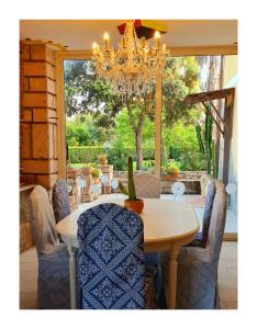 a dining room table with chairs and a chandelier at Sa Branda Costa Country Alghero in Santa Maria la Palma