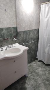 uma casa de banho com um lavatório branco e um chuveiro em Hotel Valle Del Sol em Merlo
