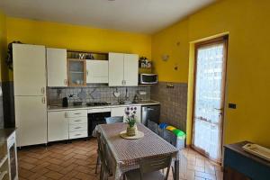 a kitchen with a table and a white refrigerator at Casa con incantevole panorama in Bevagna