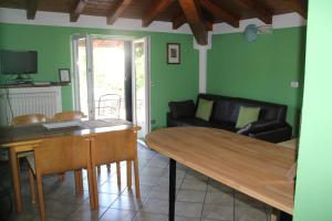 ein Wohnzimmer mit einem Tisch und einem Sofa in der Unterkunft Veranda Beach Apartment in Pianello Del Lario