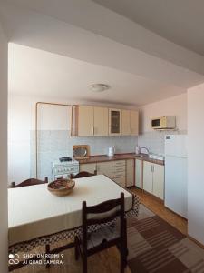una cucina con tavolo e frigorifero bianco di Almir Apartman a Sarajevo