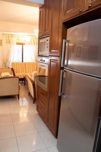 Il comprend un salon et une cuisine équipée d'un réfrigérateur en acier inoxydable. dans l'établissement Luxury Apartment, near Pinikoudes beach, à Larnaka