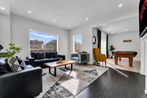 a living room with a couch and a table at Oshawa Family Haven - Luxury 7BR Villa with Cozy Fireplaces & Hot Tub in Oshawa