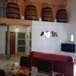 a living room with a red couch and wooden ceiling at "Le Mas" Les jardins de Tourneige in Maraussan
