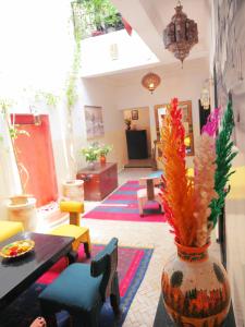 una sala de estar con un jarrón con flores. en SARDINAS & CHILI en Marrakech