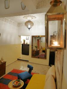 un soggiorno con divano, tavolo e specchio di SARDINAS & CHILI a Marrakech