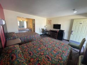 a hotel room with two beds and a desk at Village Inn in Ada