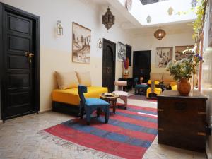 un soggiorno con divano giallo e sedie di SARDINAS & CHILI a Marrakech