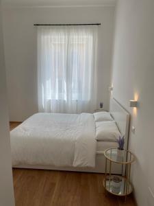 una camera con un letto bianco e una finestra di A un passo dalla piazza ad Ascoli Piceno