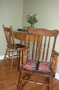 una silla de madera con una mesa y un jarrón de flores en B&B La Bedondaine, en Quebec 19 fotos más