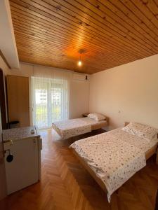 een kamer met 2 bedden en een houten plafond bij Summer Sky in Ulcinj
