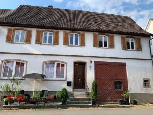 a large white house with a brown garage at Barocke Stadtvilla Ophelia nahe Europapark 45qm 1,5 Zi Studio in Ettenheim