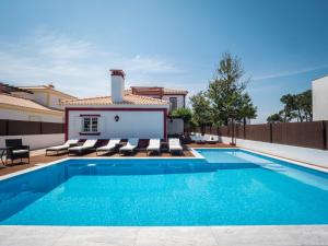 uma piscina com cadeiras e uma casa em Romã do Meco na Aldeia do Meco