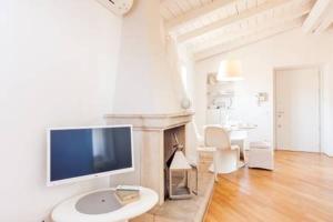 un soggiorno con TV e camino di Di punto in bianco home a Verona