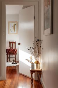 a hallway with a door with a table and a chair at Driftwood Rest Binalong Bay Sleeps 4 in Binalong Bay