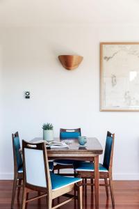 a dining room table with chairs and a plant on it at Driftwood Rest Binalong Bay Sleeps 4 in Binalong Bay