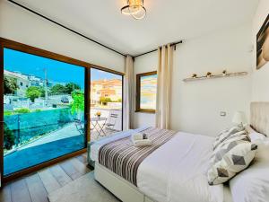 - une chambre avec un lit et une grande fenêtre dans l'établissement Palmira Cascais House, à Alcabideche