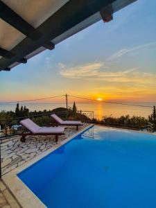 a swimming pool with a sunset in the background at Villa Ioanna in Kalamitsi