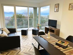 uma sala de estar com uma mesa e cadeiras e uma televisão em Disfruta la vista del Canal de Beagle! Departamento tranquilo rodeado de Árboles y montañas em Ushuaia