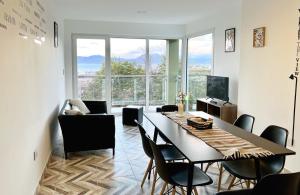 a dining room with a table and chairs and a large window at Disfruta la vista del Canal de Beagle! Departamento tranquilo rodeado de Árboles y montañas in Ushuaia