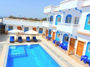 a villa with a swimming pool in front of a building at Dahab Beach Lodge in Dahab