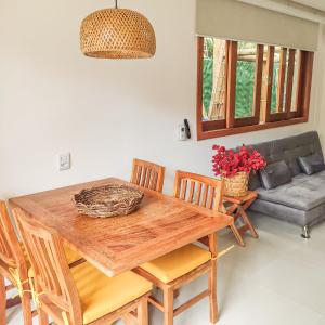a dining room with a wooden table and chairs at Flat em Taipu de Fora - Cond Vila Taipu in Barra Grande