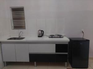 a kitchen with a counter with a sink and a microwave at Kitnet Vila Marcela in Petrolina