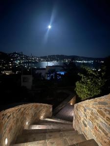a moon over a city at night with a stone staircase at seaview Foinikas in Finikas
