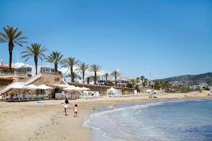 two children walking on the beach near the ocean at Centro Sitges in Sitges