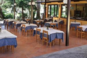 a restaurant with white tables and chairs with blue table cloth at Hotel Residence Il Rifugio in Palinuro