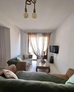 a living room with two couches and a tv at seaview Foinikas in Finikas
