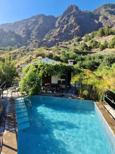 a swimming pool with mountains in the background at Villa de Taburiente in El Paso