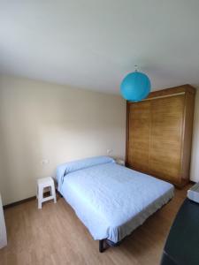 a bedroom with a large bed and a blue lamp at Apartamento en Finisterre Fisterra in Finisterre