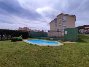 a small swimming pool in a yard next to a building at Apartamento en Finisterre Fisterra in Finisterre +5 photos