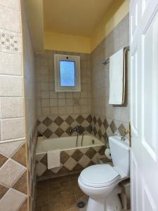 een badkamer met toilet en ligbad bij Villa Ioanna in Kalamitsi