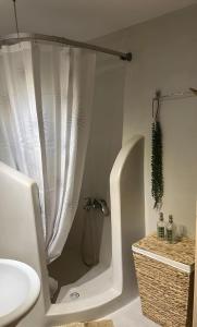 a bathroom with a shower with a tub and a sink at seaview Foinikas in Finikas