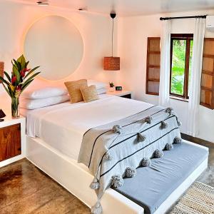 een slaapkamer met een wit bed en een grote spiegel bij Vayu Retreat Villas in Coronado