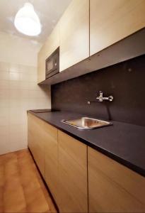 una cucina con lavandino e armadi in legno di Bellagio Ghisallo Penthouse a Bellagio