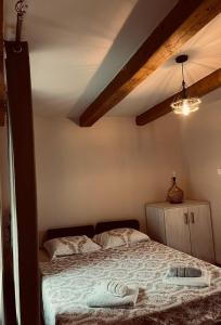 a bedroom with a bed in a room with beams at Old wine in Virpazar