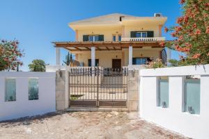 a house with a gate and white fences at Emily Apartment in Zakynthos Town