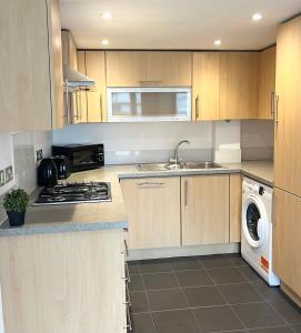 a kitchen with a sink and a stove top oven at Beautiful Riverview Apartment Chelmsford in Chelmsford