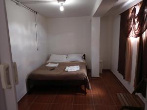 1 dormitorio con 1 cama con 2 toallas en Casa da Dine - Cama & Café, en Campos do Jordão