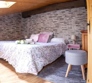 um quarto com uma cama e uma parede de tijolos em Casa Rural El Burrito de Gredos em Pedro Bernardo