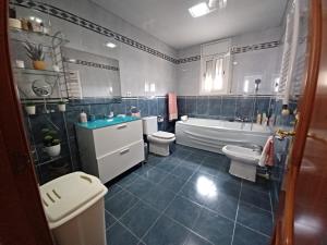 y baño con 2 aseos, bañera y lavamanos. en Chalet Costa Dorada en Tarragona
