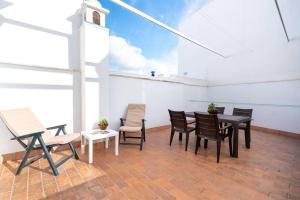 une salle à manger avec une table, des chaises et un ciel. dans l'établissement Cómodo apartamento en Almonte, à Almonte