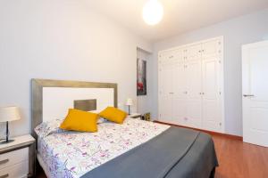 a bedroom with a bed with two yellow pillows at Cómodo apartamento en Almonte in Almonte