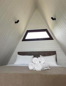 ein Bett mit Handtüchern darauf im Dachgeschoss in der Unterkunft UkhutiEcoHouse in Vani