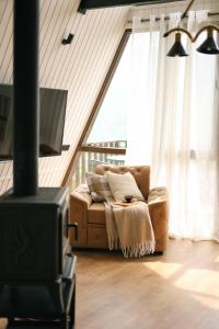 a living room with a couch and a tv at UkhutiEcoHouse in Vani